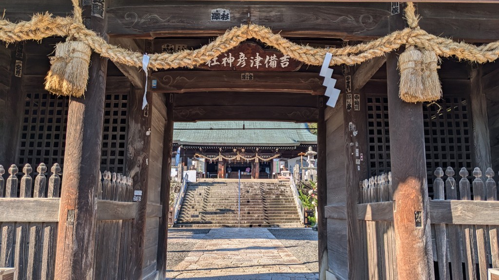 随神門の中から拝殿を望む。注連縄が掛けられ、天井付近には吉備津彦神社と書かれた看板が掲げられている。